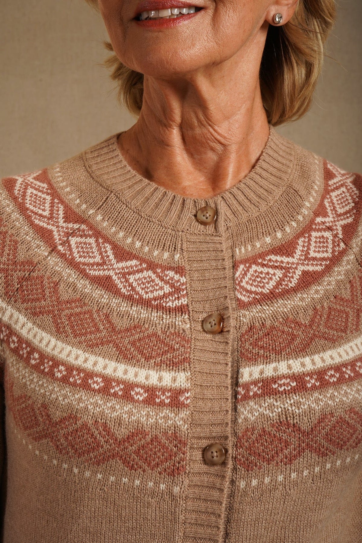Woman standing outdoors wearing a long-sleeved button-front knit cardigan with a patterned Fair Isle yoke, ribbed crew neck, cuffs and hem, with jeans._2