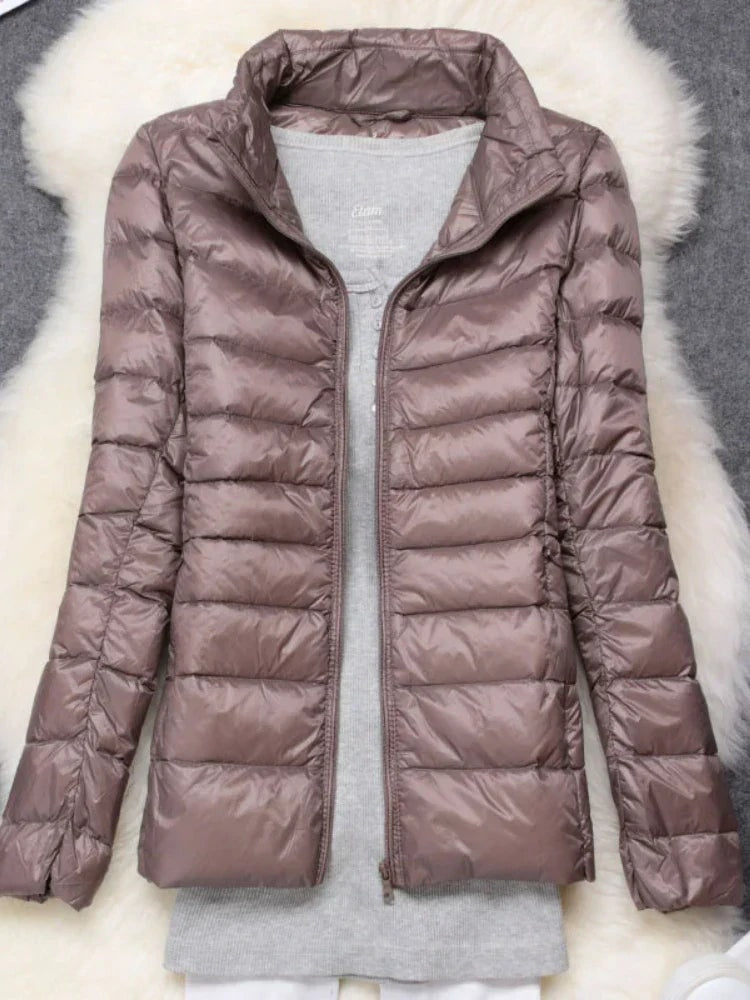 Taupe quilted puffer jacket shown open over a gray top, highlighting its interior.