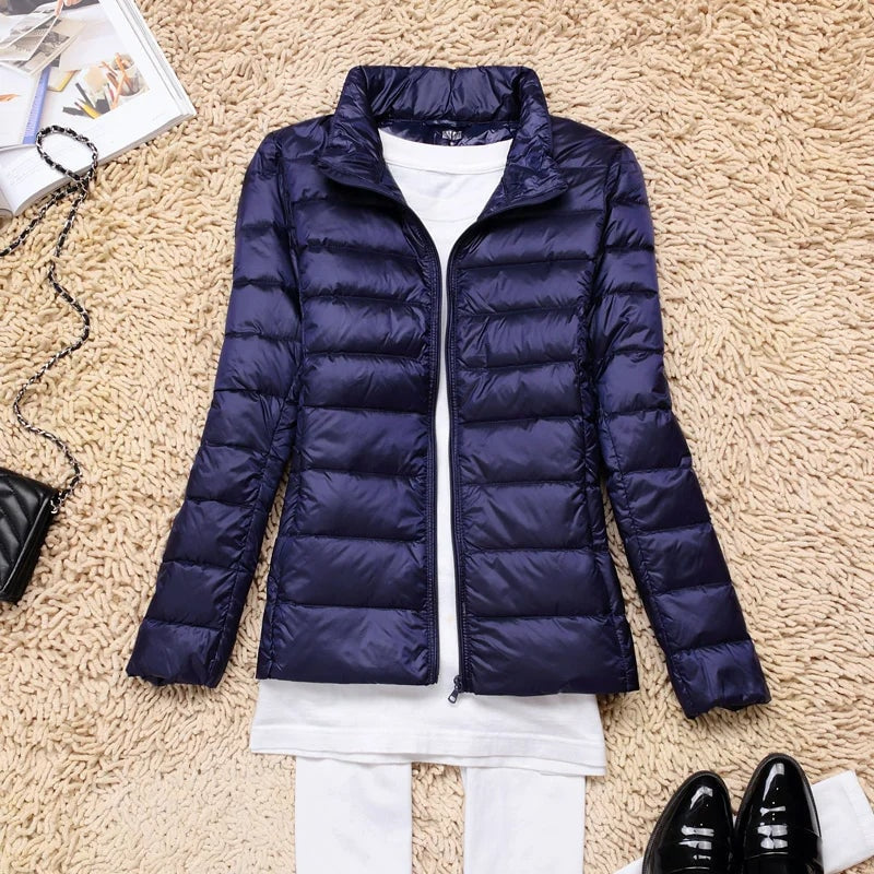 Navy blue quilted puffer jacket displayed open with a stand collar and zip front.