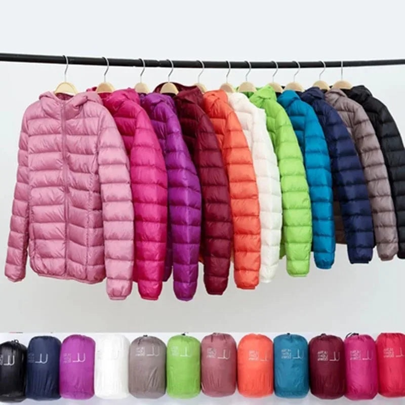 A row of hooded quilted puffer jackets in multiple colors hanging on a rail above matching compact bundles.