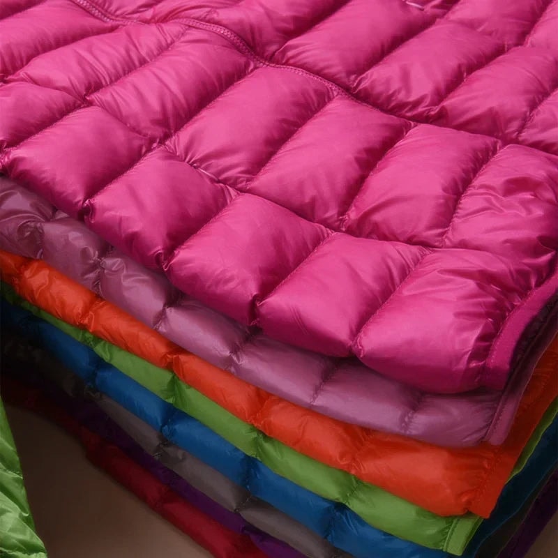 Close-up of colorful quilted puffer jackets stacked to emphasize their padded horizontal channels.