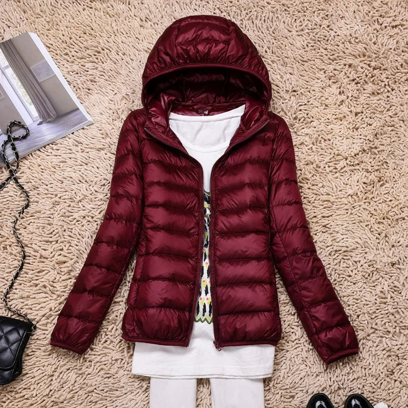 Deep burgundy hooded quilted puffer jacket displayed open against a textured rug.