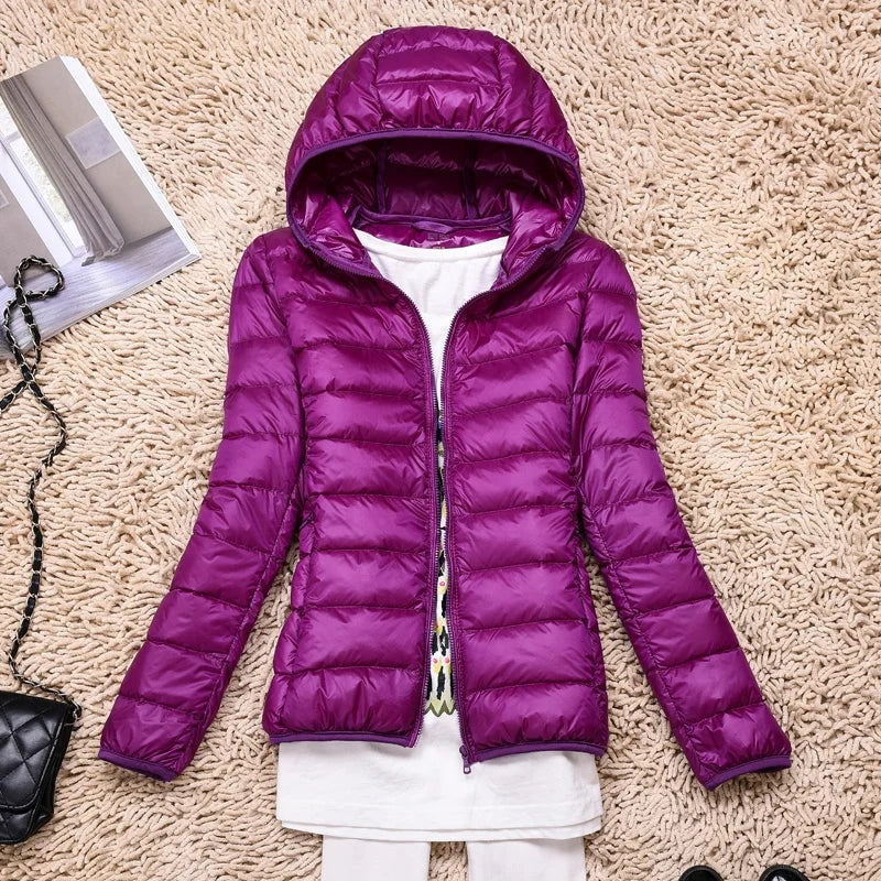 Purple hooded puffer jacket laid flat with its front zipper open.