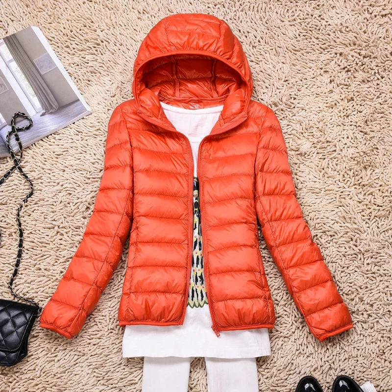 Bright orange hooded quilted jacket shown open against a textured rug.