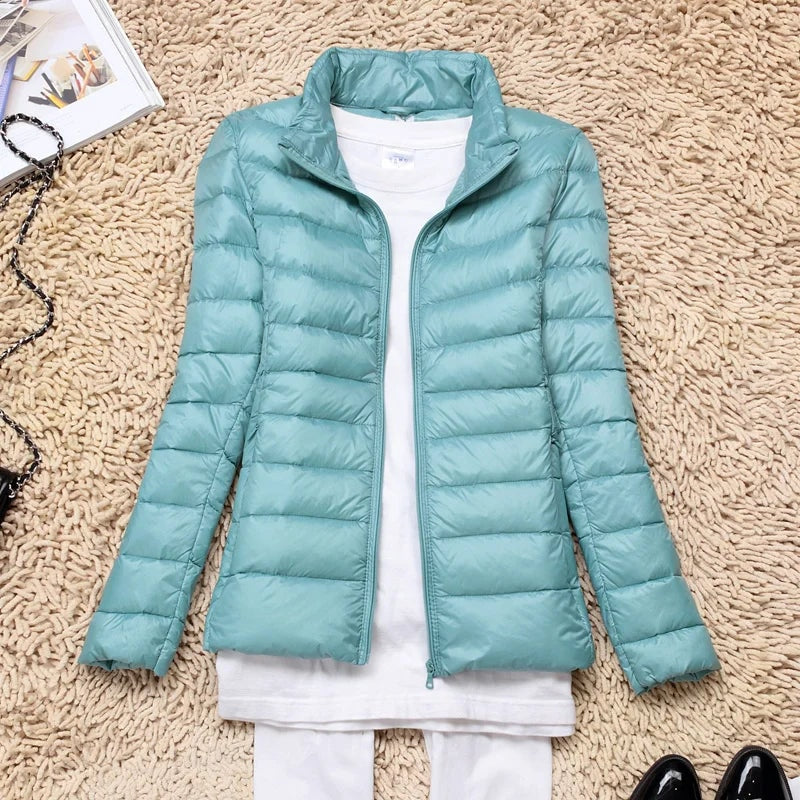 Light aqua quilted puffer jacket shown without a hood and with its front zipper open.