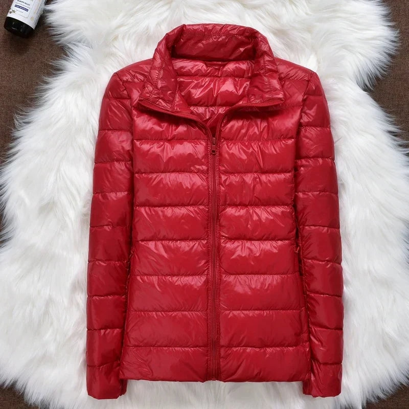 Red quilted puffer jacket displayed fully zipped on a white faux-fur surface.