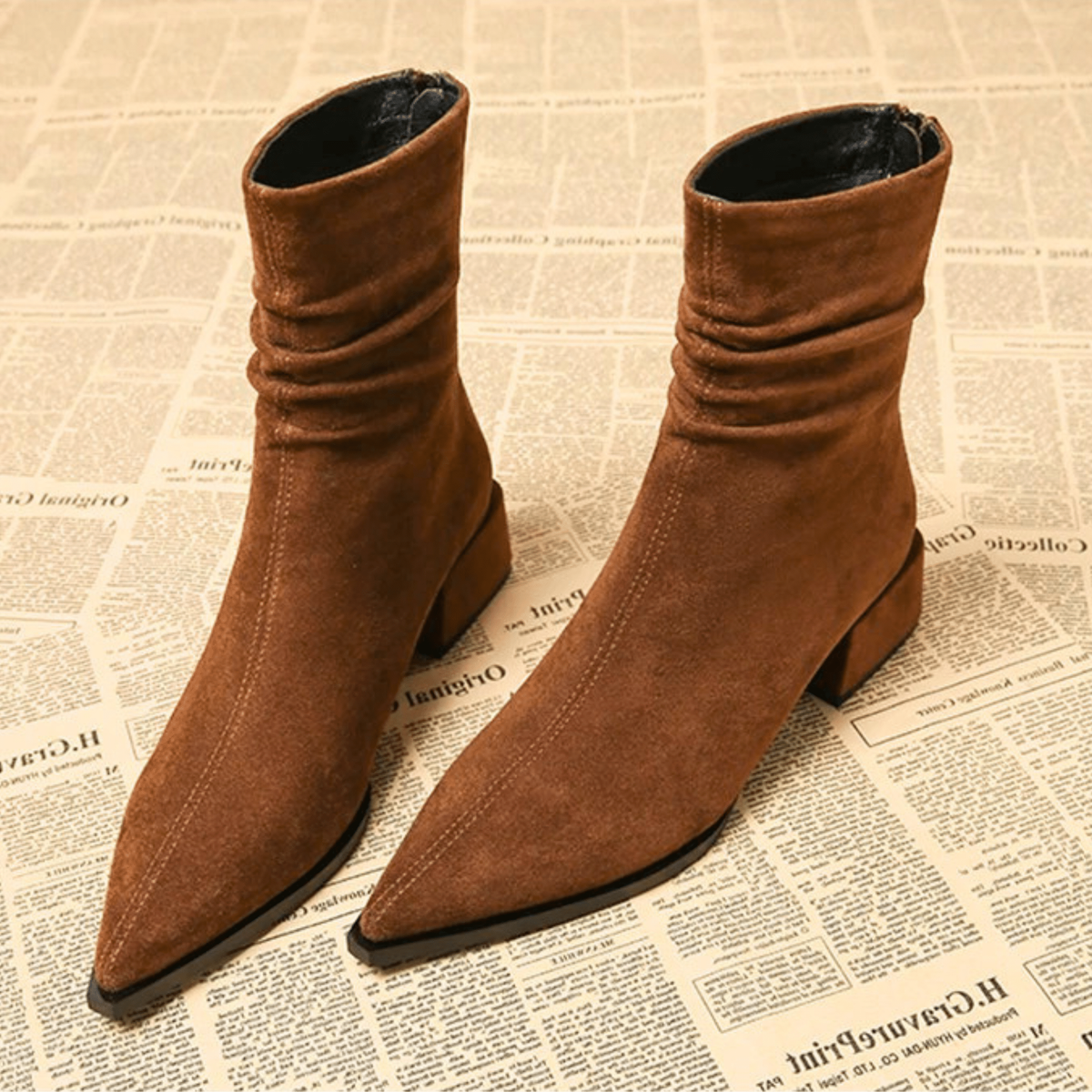 Brown pointed-toe ankle boots with ruched shafts and block heels, shown together from the front.