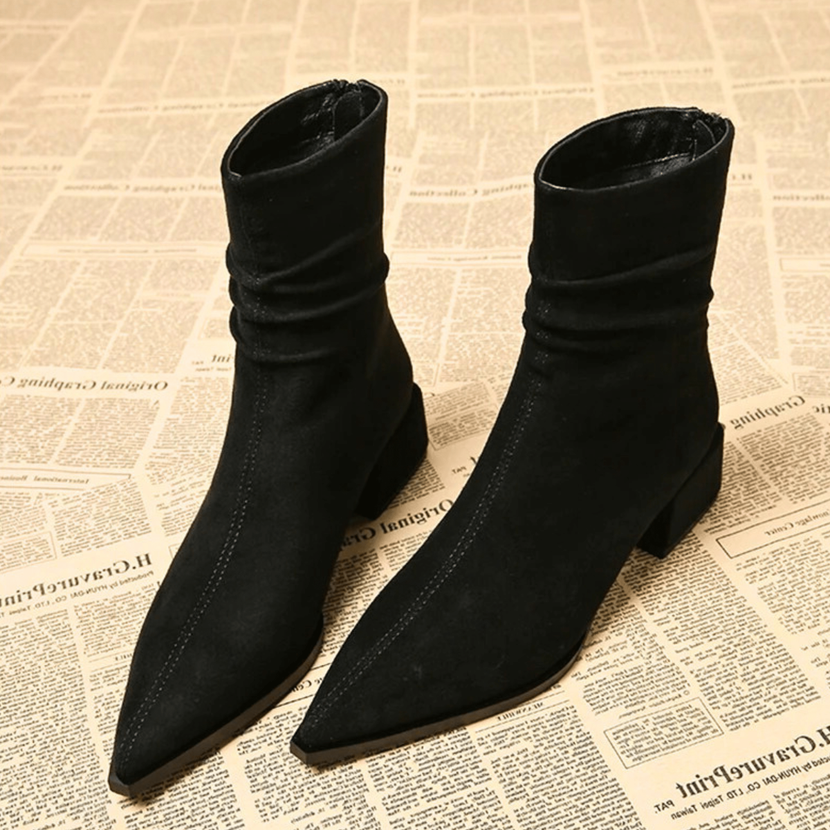 Black pointed-toe ankle boots with ruched ankle shafts and block heels, shown together from the front.