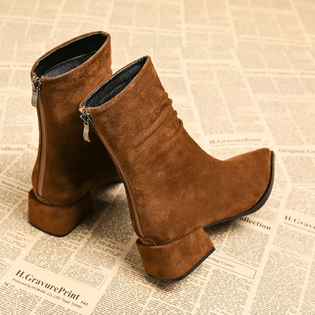 Brown ankle boots shown from the back and side, revealing the full-length side zippers, ruched shafts, and block heels.