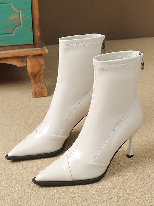 Black pointed-toe ankle boots with stiletto heel and back zipper closure modeled on feet._2