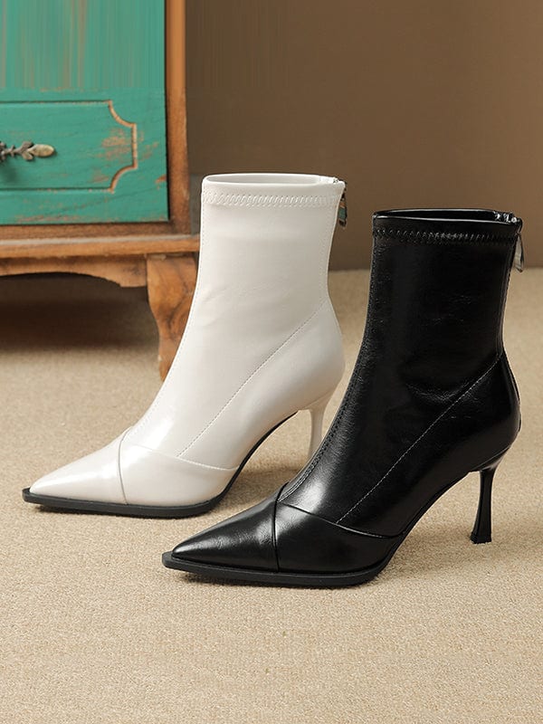 Black pointed-toe ankle boots with stiletto heel and back zipper closure modeled on feet._7