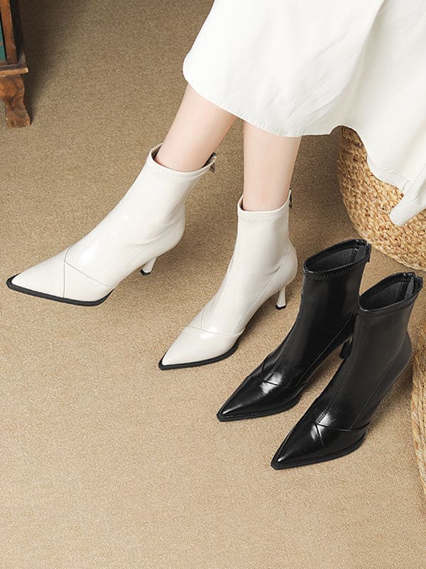 Black pointed-toe ankle boots with stiletto heel and back zipper closure modeled on feet._8