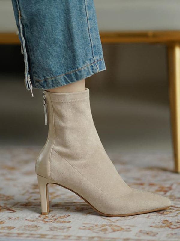Woman wearing beige pointed toe sock boots with mid heel and back zipper, styled with cropped jeans._2