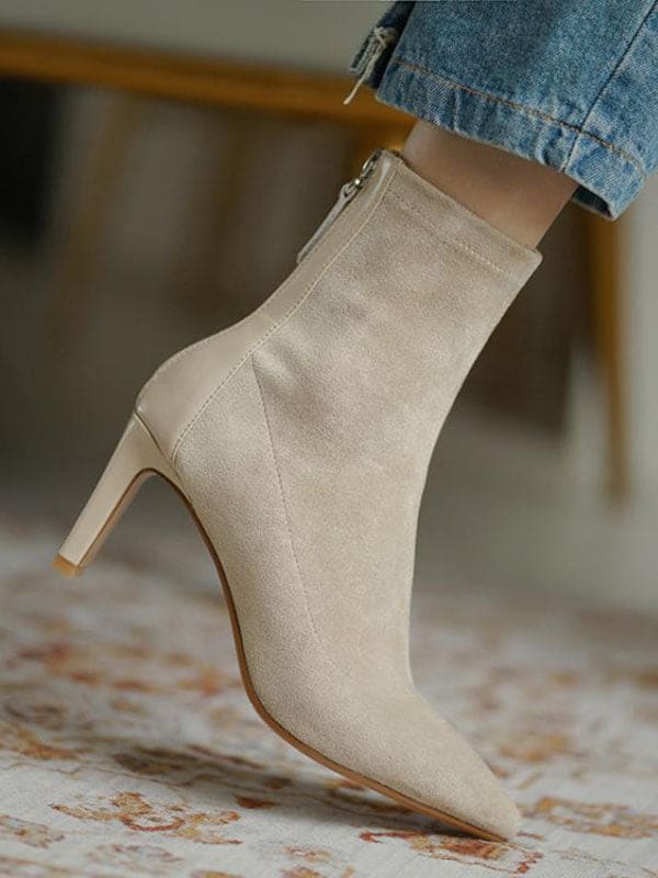 Woman wearing beige pointed toe sock boots with mid heel and back zipper, styled with cropped jeans._3
