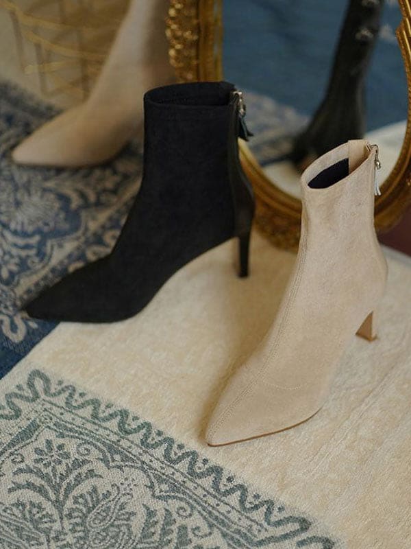 Woman wearing beige pointed toe sock boots with mid heel and back zipper, styled with cropped jeans._6