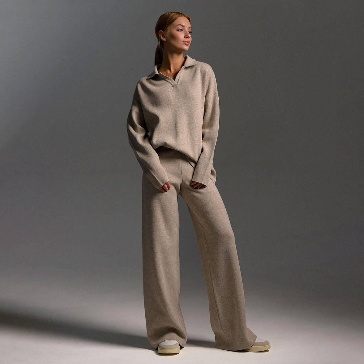 Model in the taupe matching set standing with one leg angled outward.