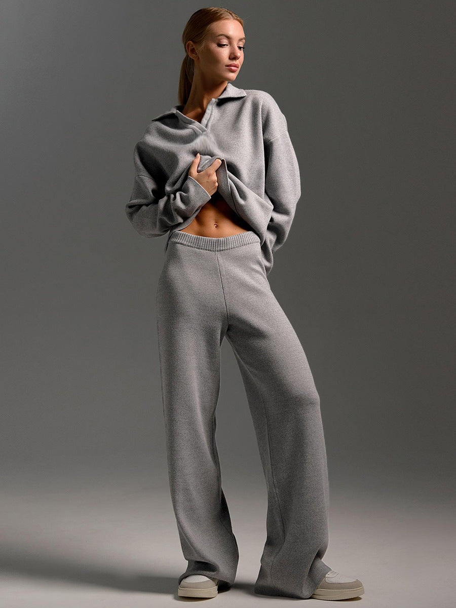 Model wearing the gray set while lifting the sweater to show the pants waistband.