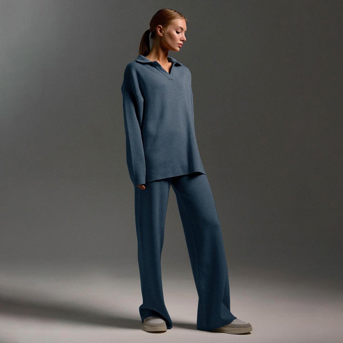 Model shown in a blue polo sweater and matching wide-leg pants with a side-facing stance.