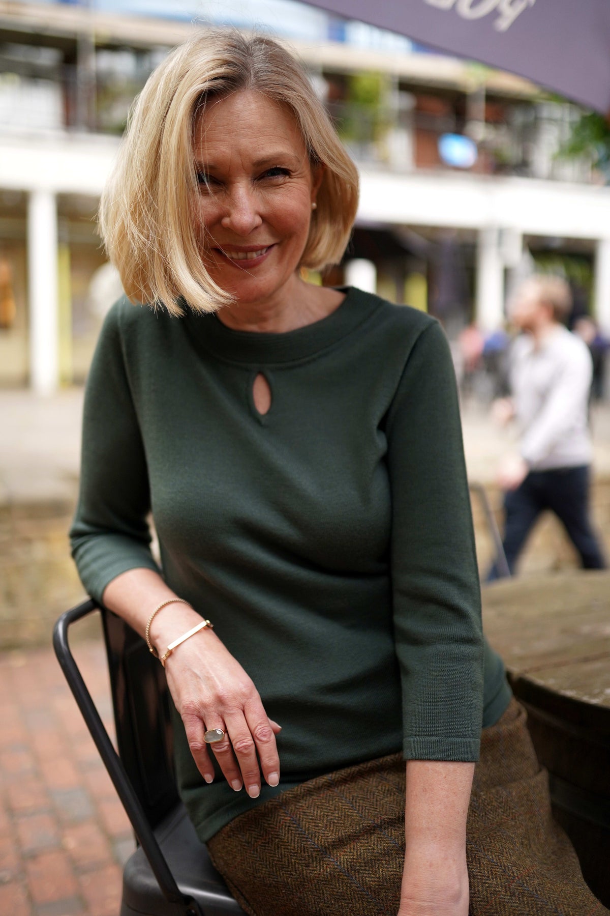 Woman wearing a fine knit long sleeve jumper with a ribbed round neckline and small keyhole opening at the centre front._3