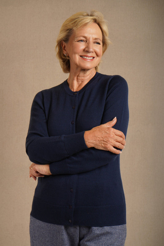 Woman wearing a long sleeve button front knit cardigan with a round neckline and ribbed cuffs and hem, with trousers._0