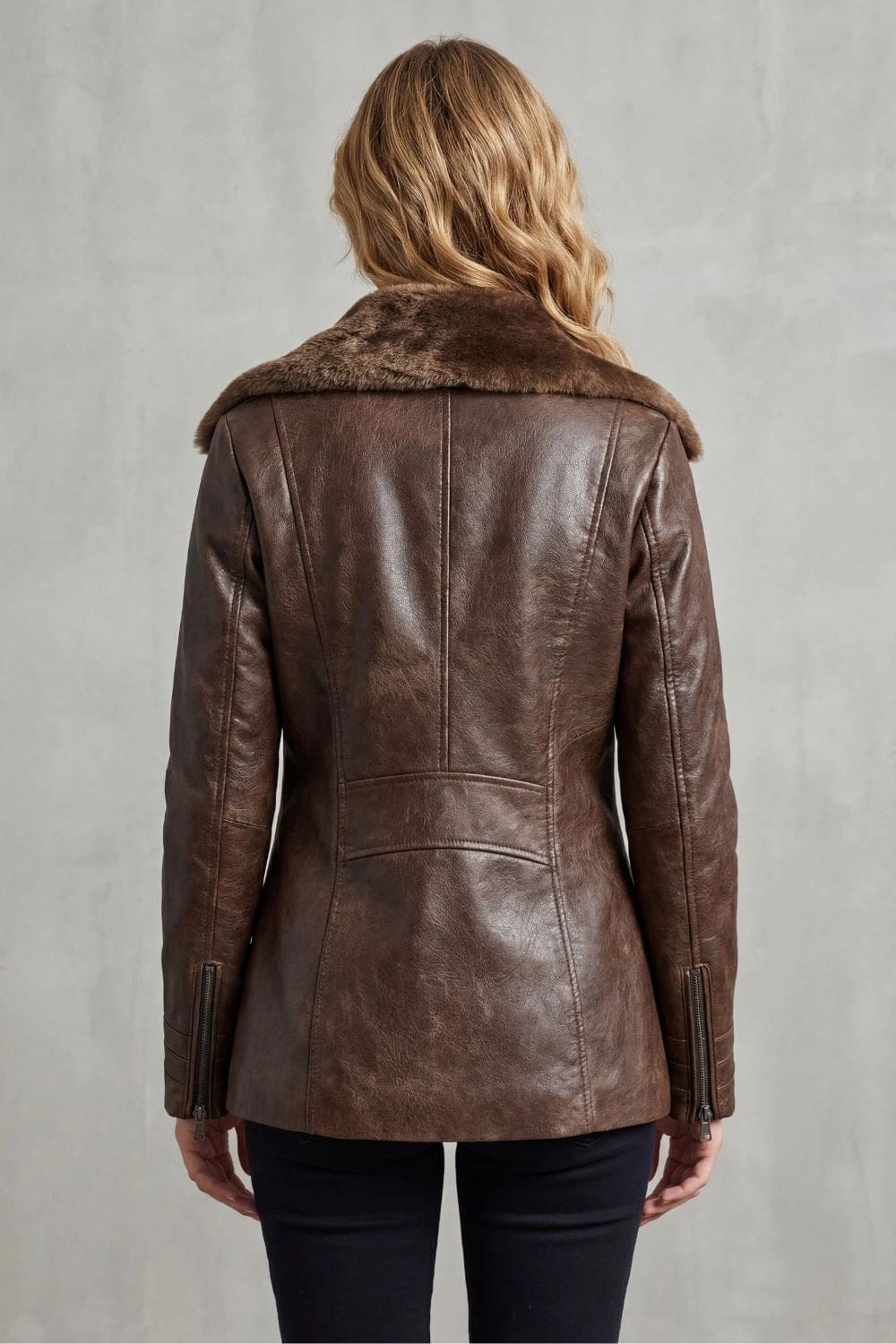 Woman viewed from behind wearing a hip-length zip-front jacket with a faux fur collar, welt pockets and ribbed sleeve detail._9