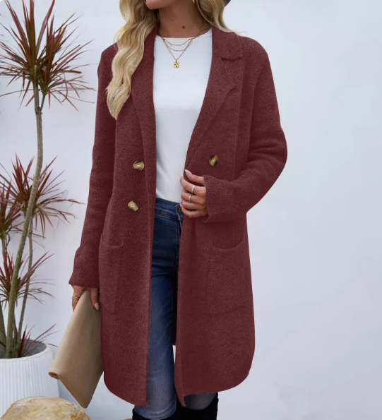 Woman wearing a long open knit coat with notched lapels, three front buttons and two patch pockets over a white top and jeans._0