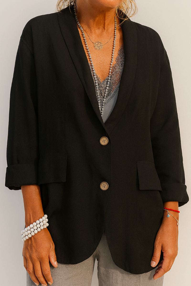 Black relaxed blazer jacket showing its open lapel, two-button closure, rolled cuffs, and flap-style front pockets.