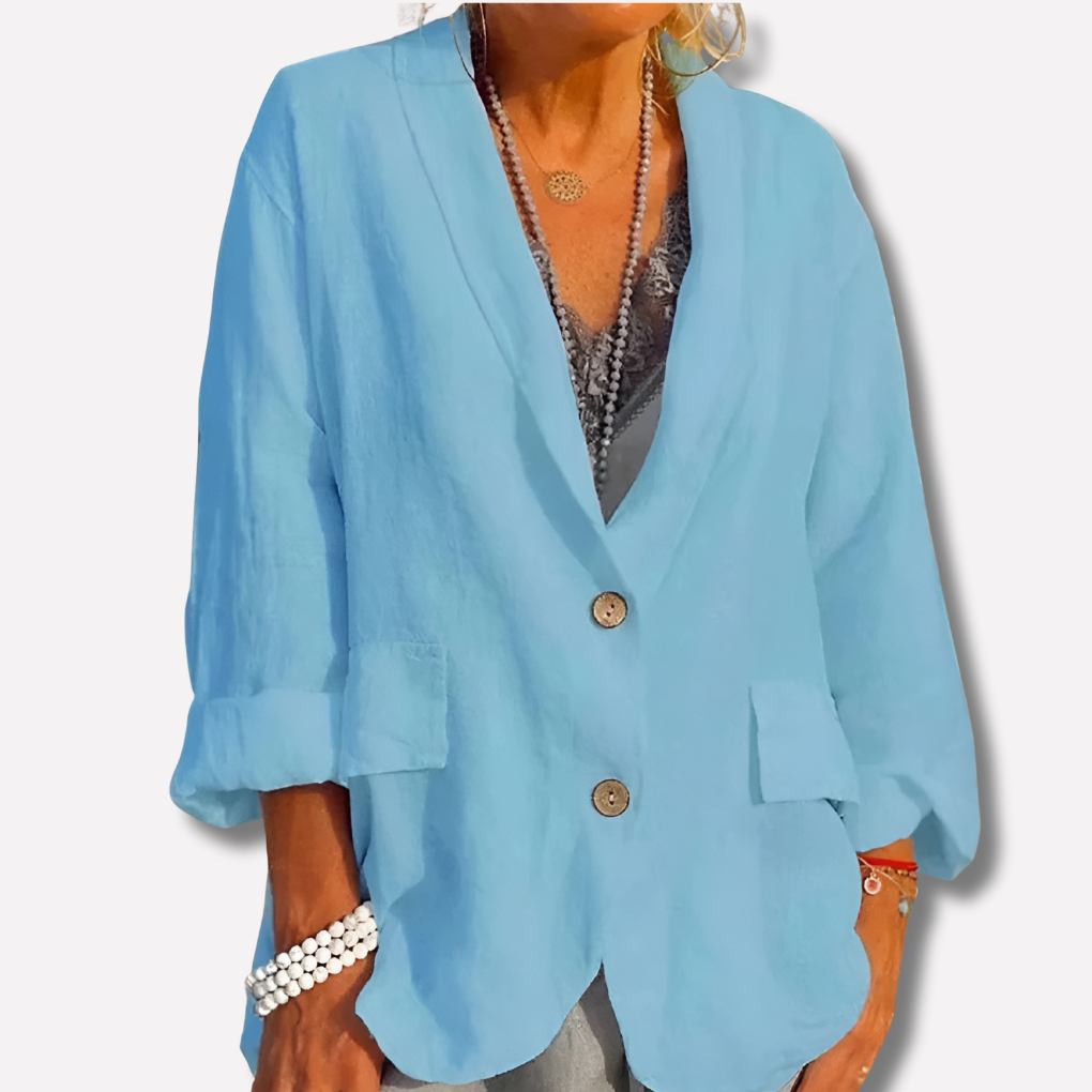 Light blue relaxed blazer jacket with an open lapel, two-button closure, rounded hem, rolled sleeves, and front patch pockets.