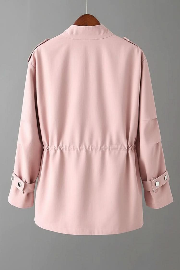 Utility style jacket with stand collar, zip and snap front, two flap chest pockets, two hip pockets, drawstring waist and tabbed cuffs, shown on a wooden hanger over a white top._1