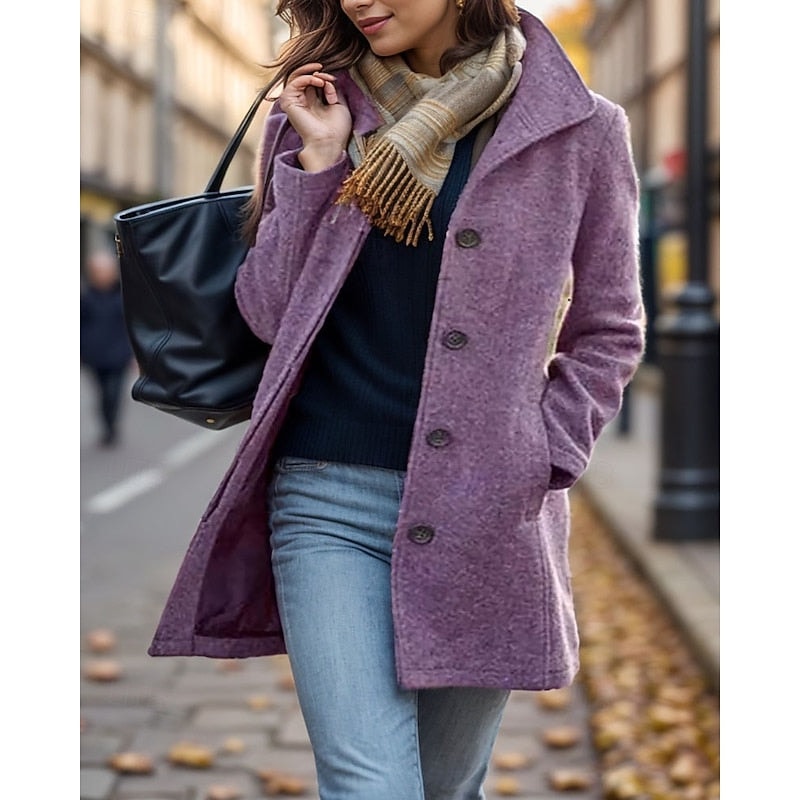 Purple women's short coat with a notched collar, button front, long sleeves, and side pockets, styled with jeans on a city street.