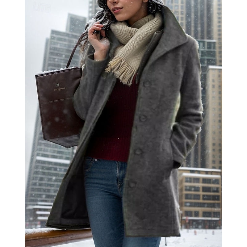 Charcoal women's short coat with a notched collar and button front, worn in a snowy city setting with the front opening slightly visible.