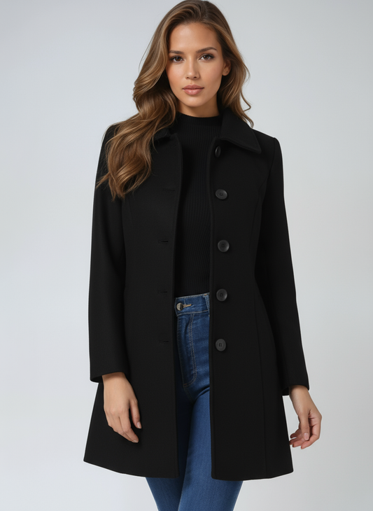 Black single-breasted winter coat with a structured pointed collar, long sleeves, and above-knee length, styled open over a black top and jeans.