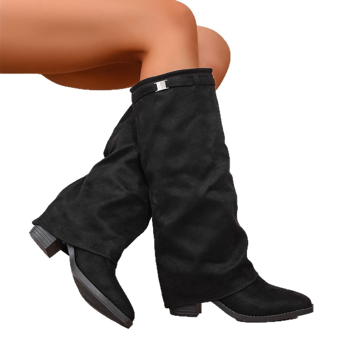 Black slouch boots crossed against a white background, revealing the low block heels and textured outsole.