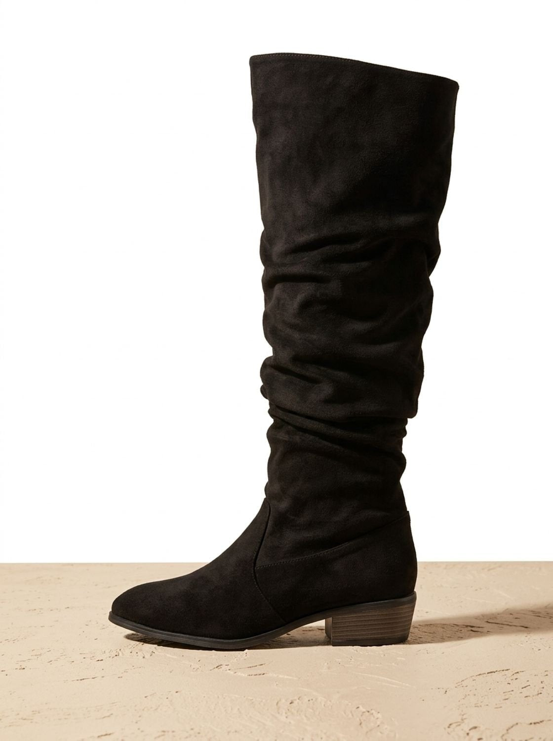 Single black slouchy over-the-knee boot shown in profile against a light background.