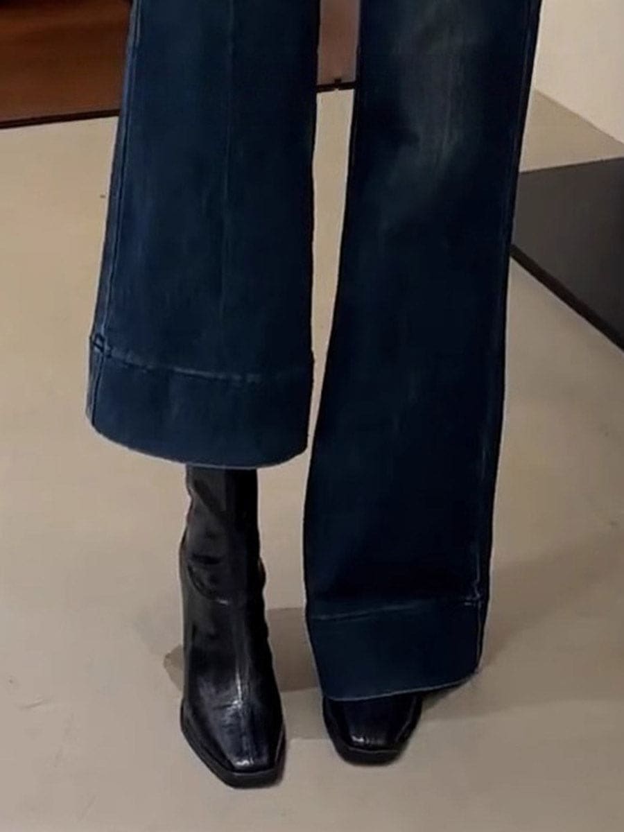 A pair of black ankle boots with a square toe and block heel worn with blue jeans._2
