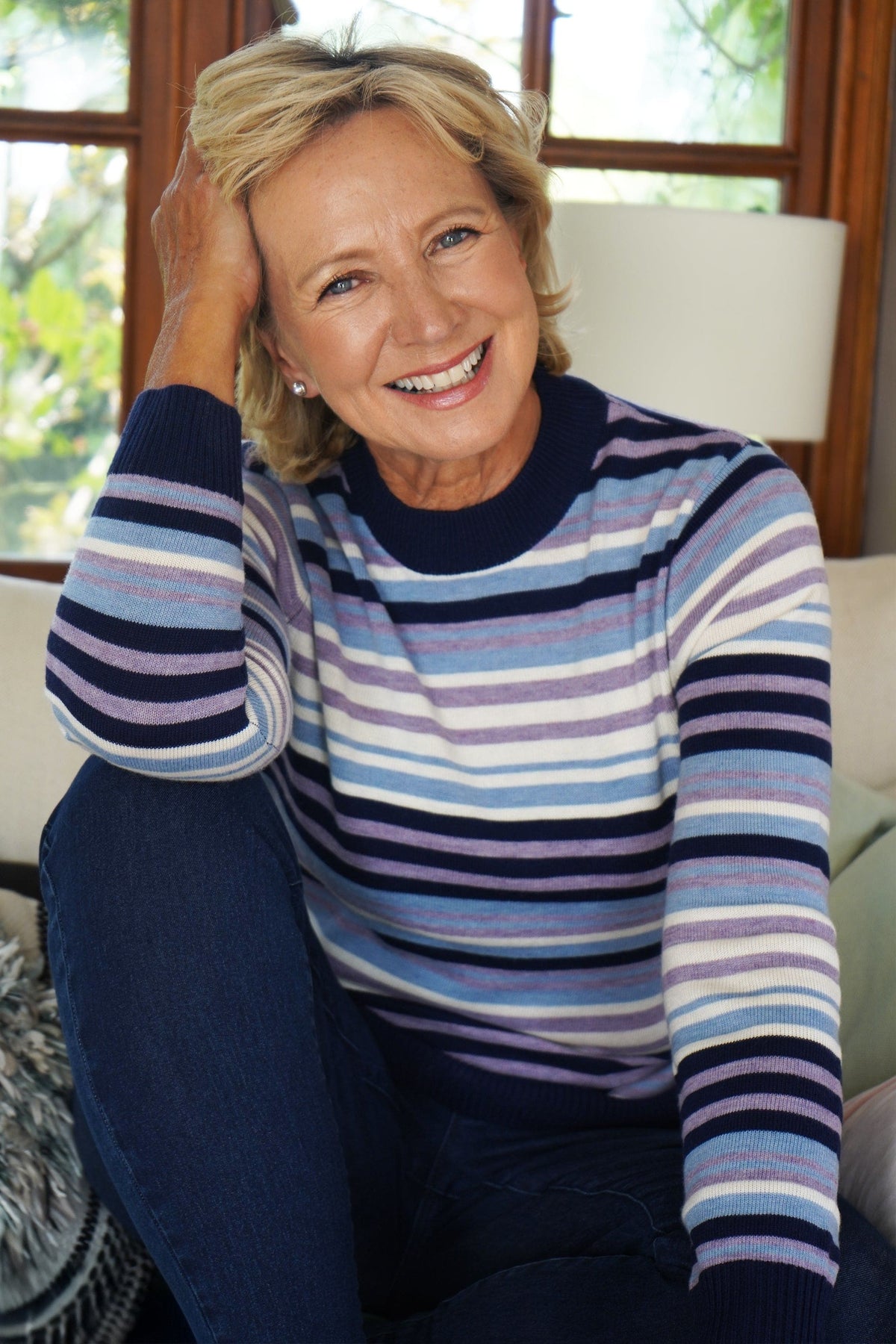 Woman wearing a long sleeve striped knit jumper with a ribbed crew neck, cuffs and hem, standing beside a wooden gate._3