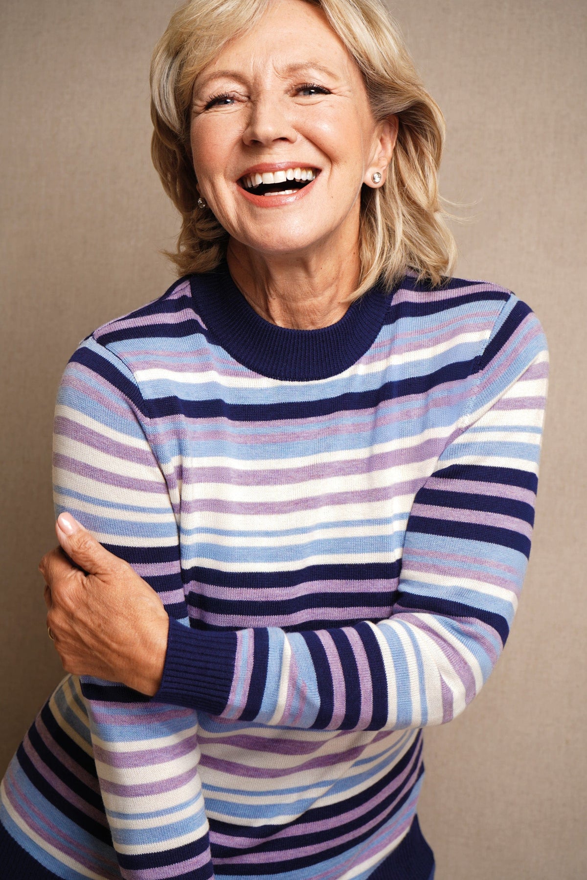 Woman wearing a long sleeve striped knit jumper with a ribbed crew neck, cuffs and hem, standing beside a wooden gate._4