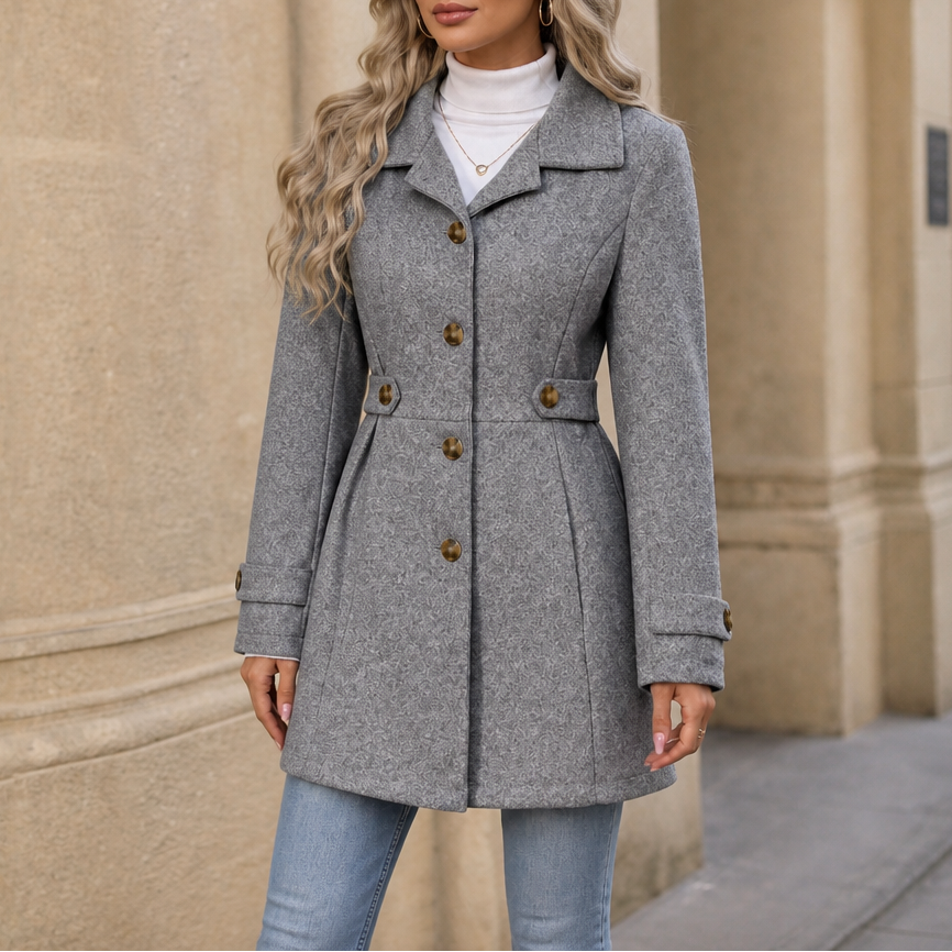Gray colorway of the tailored coat showing the notched collar, button front, waist belt, and cuff tabs.