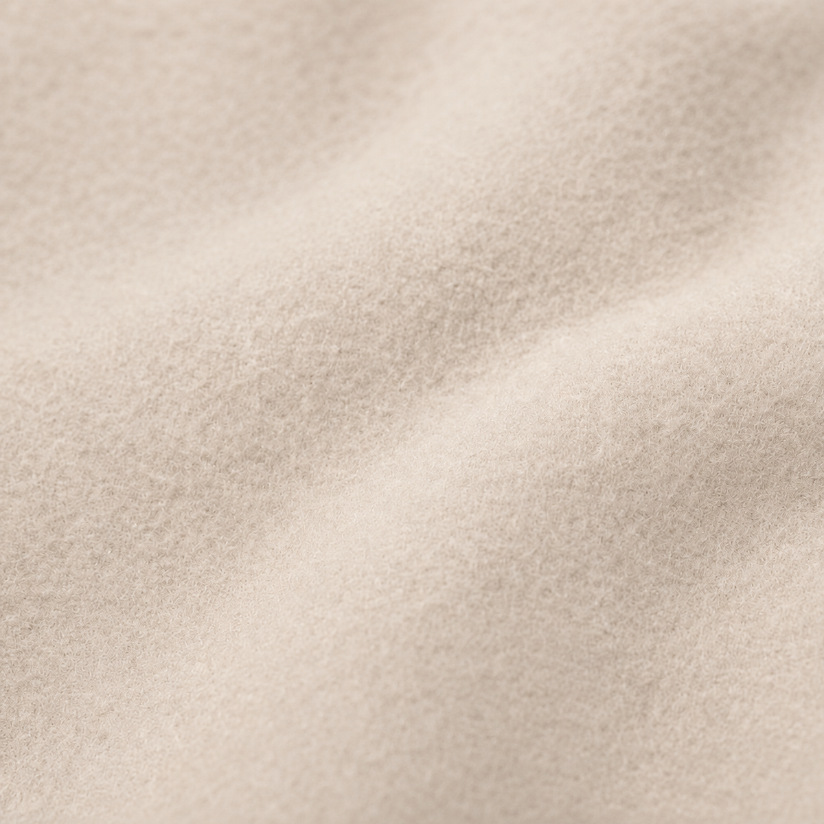 Close-up view of the coat’s light beige textured surface.