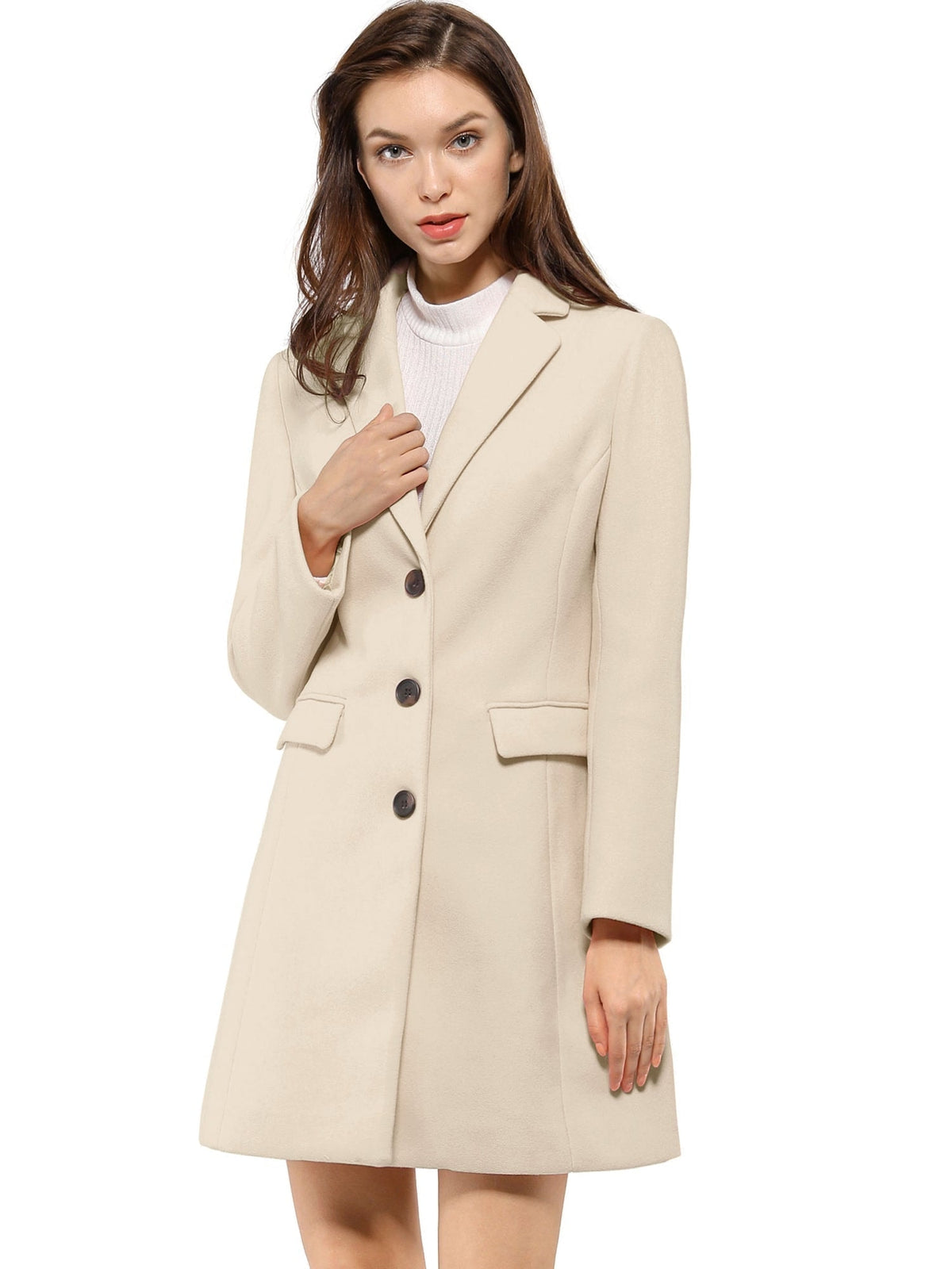Cream lapel coat shown from a slight angle as the model holds the upper front, highlighting its structured shape.