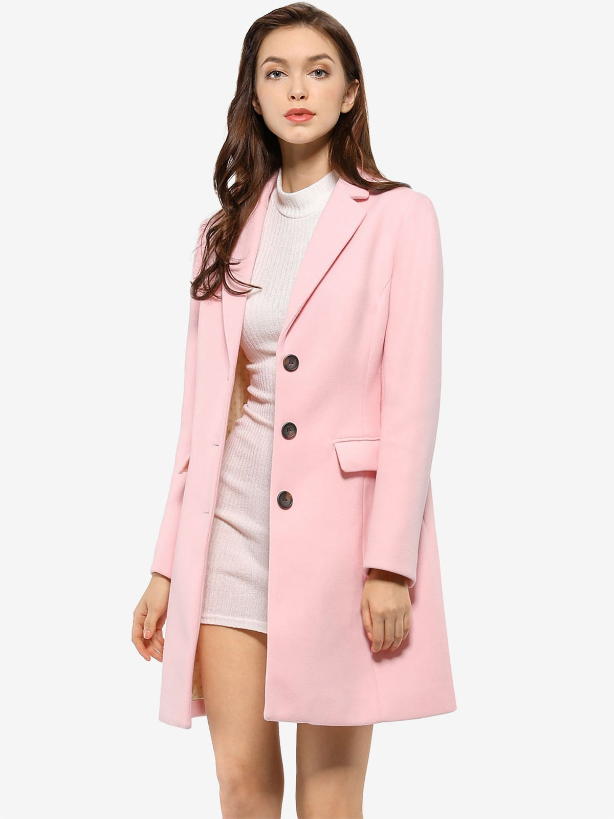 Pink tailored coat with dark buttons and a flap pocket, worn open over a light knit dress.