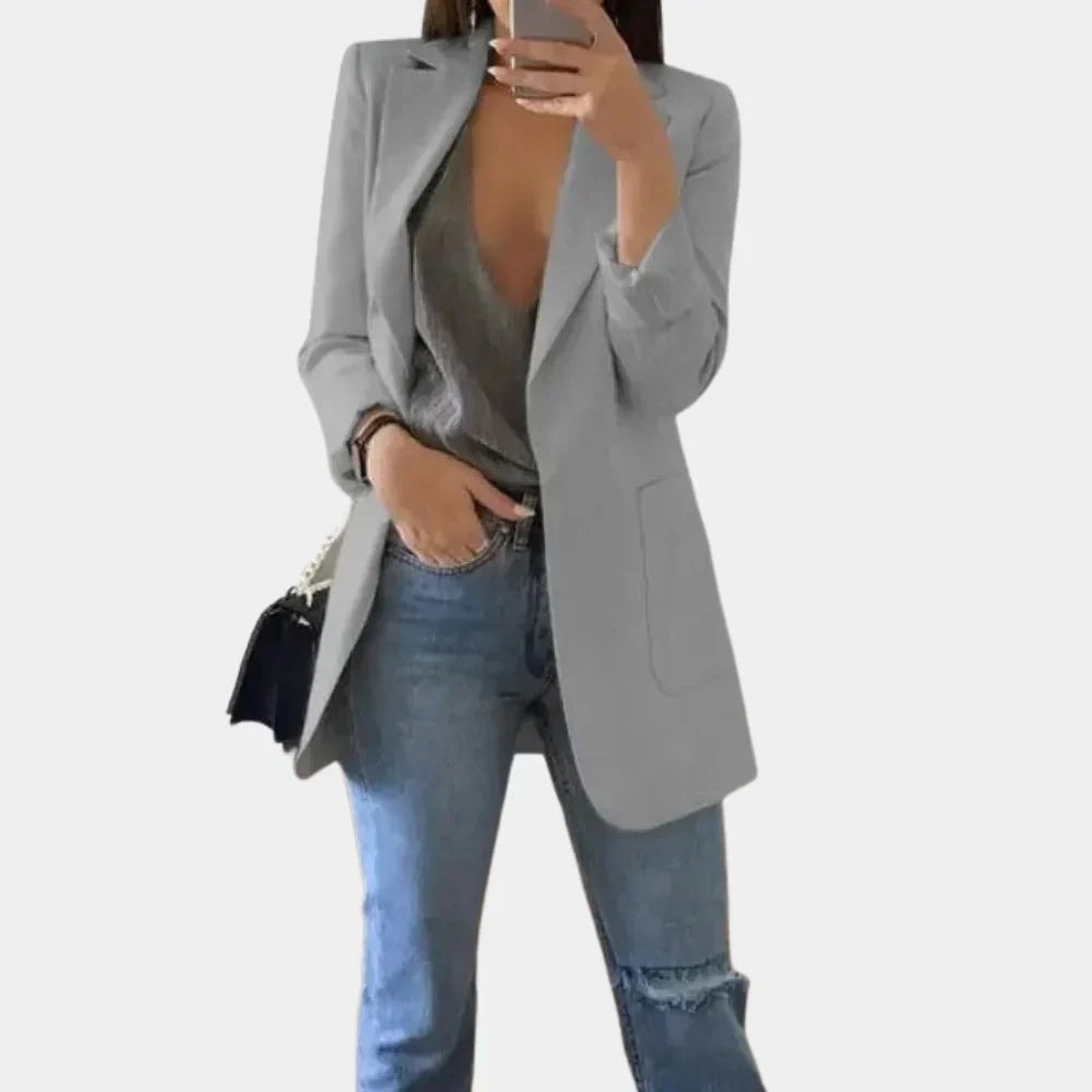 Gray longline blazer jacket with a clean tailored shape, notched lapels, and rounded front pocket detailing.