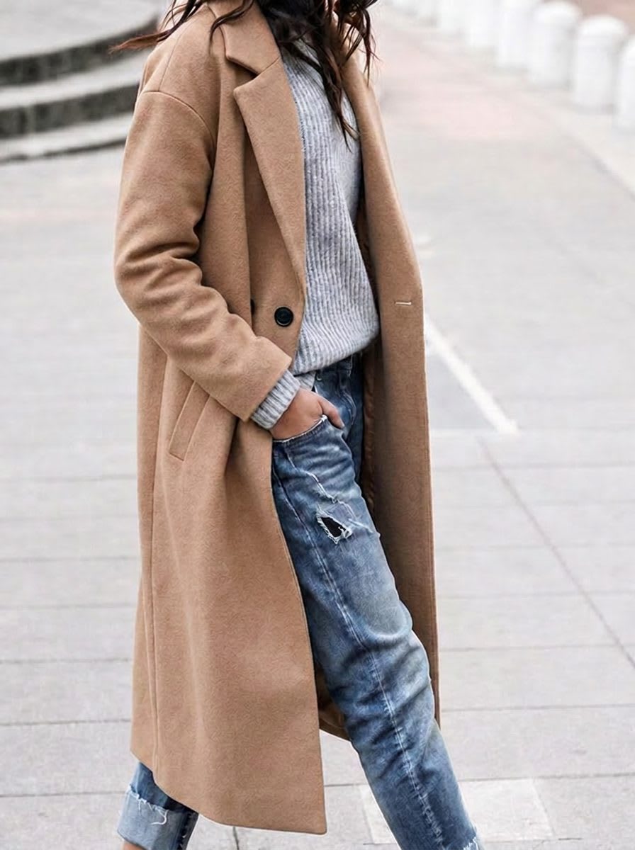 Long open coat with notch lapels, single button at the waist and side pockets, worn over a ribbed knit and jeans._0