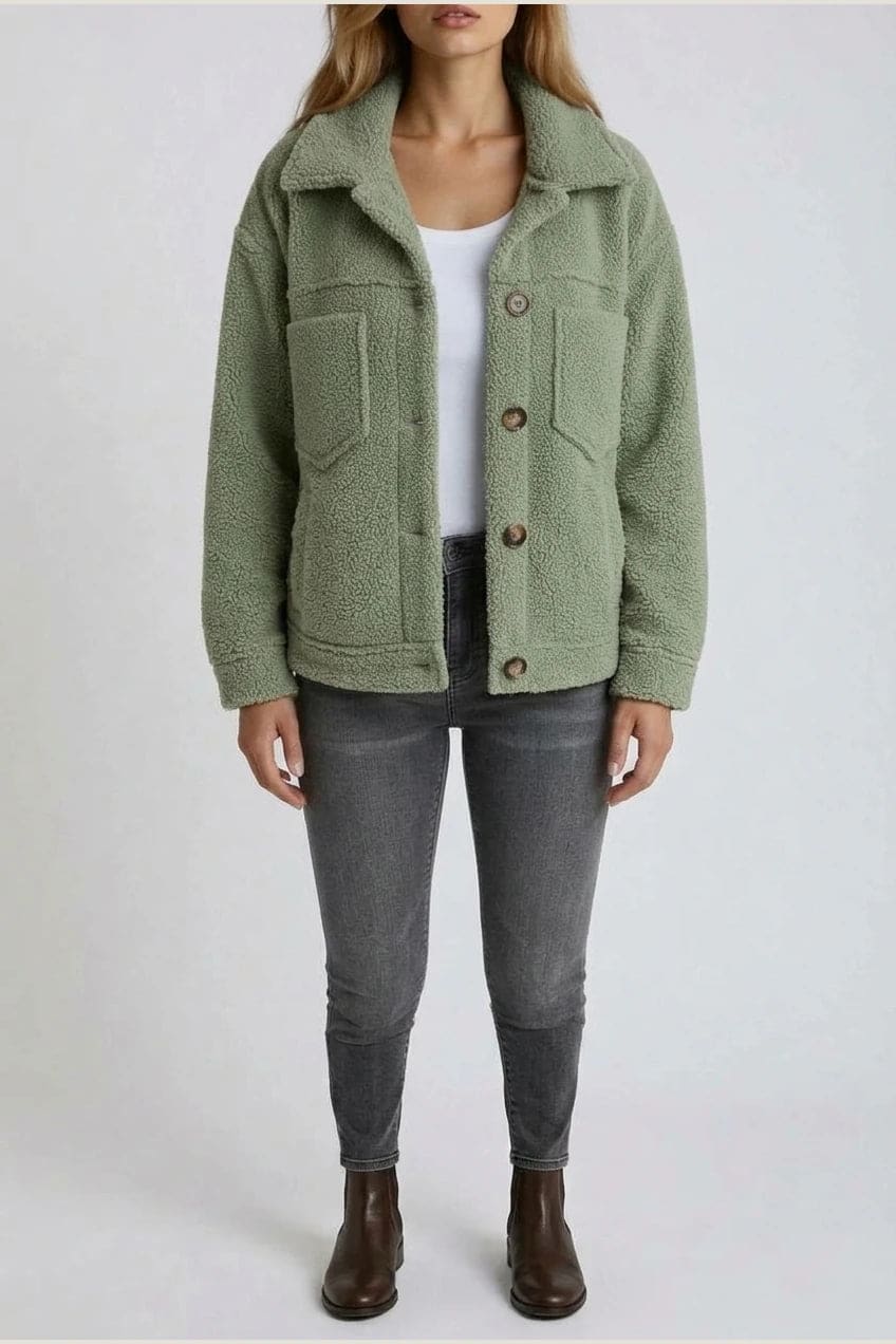 Woman wearing an open teddy-textured button-front jacket with a collar, chest pockets and lower pockets, with jeans and ankle boots._0