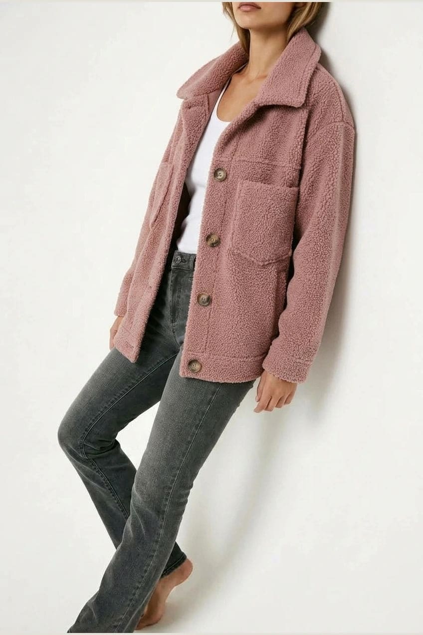 Woman wearing an open teddy-textured button-front jacket with a collar, chest pockets and lower pockets, with jeans and ankle boots._15