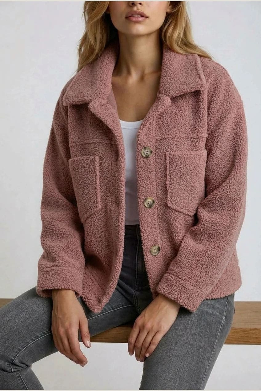 Woman wearing an open teddy-textured button-front jacket with a collar, chest pockets and lower pockets, with jeans and ankle boots._16