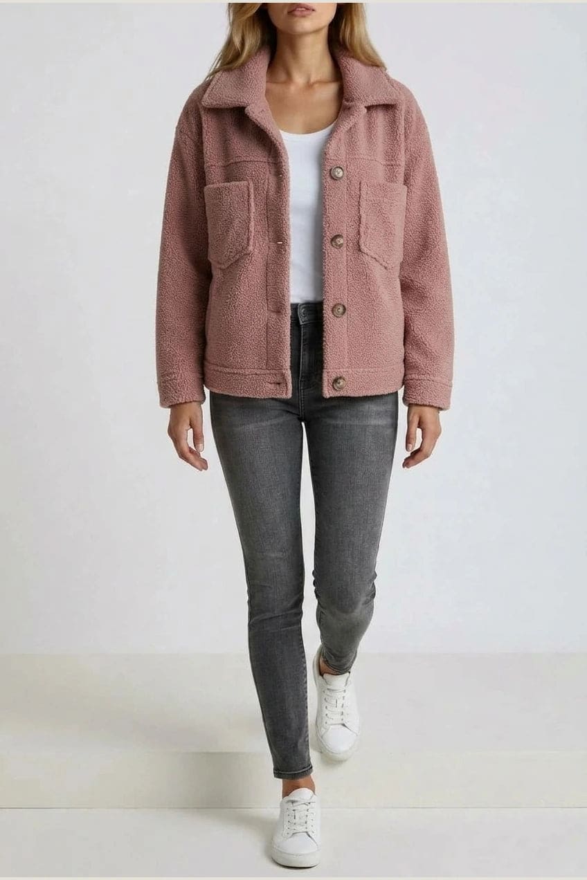 Woman wearing an open teddy-textured button-front jacket with a collar, chest pockets and lower pockets, with jeans and ankle boots._17
