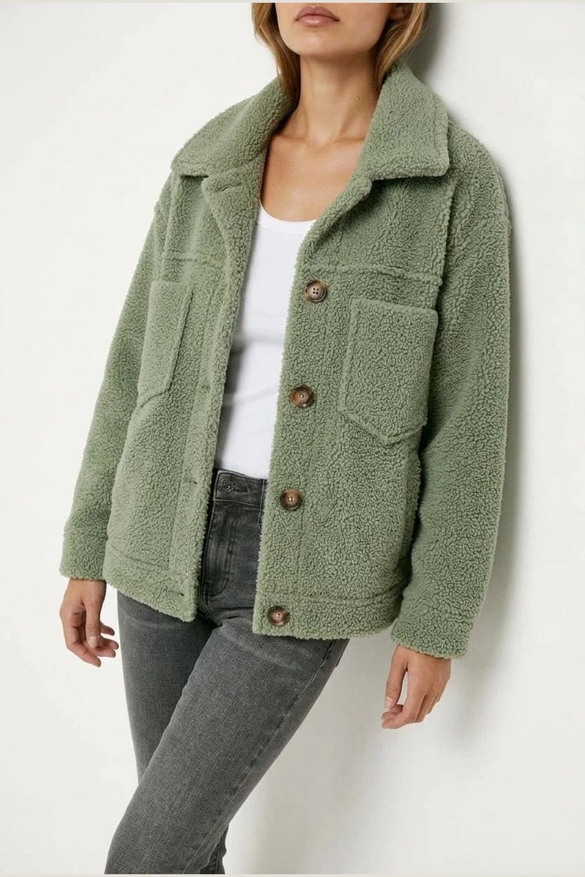 Woman wearing an open teddy-textured button-front jacket with a collar, chest pockets and lower pockets, with jeans and ankle boots._2