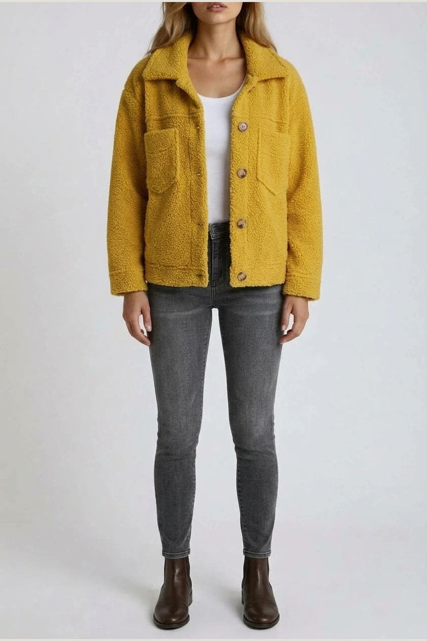 Woman wearing an open teddy-textured button-front jacket with a collar, chest pockets and lower pockets, with jeans and ankle boots._6