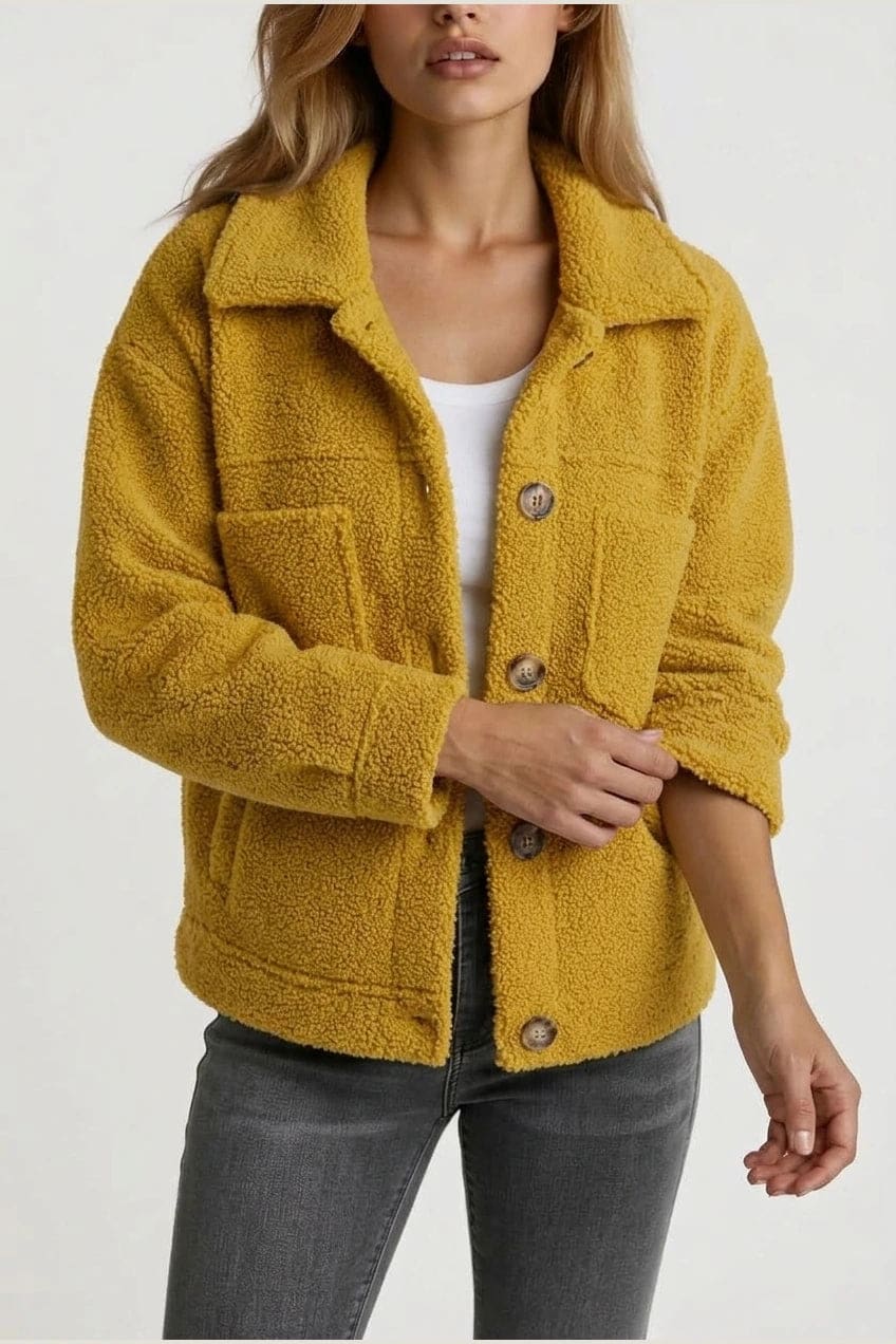 Woman wearing an open teddy-textured button-front jacket with a collar, chest pockets and lower pockets, with jeans and ankle boots._7